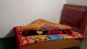 Un lit avec une couvre-lit à motifs floraux et un oreiller marron.
