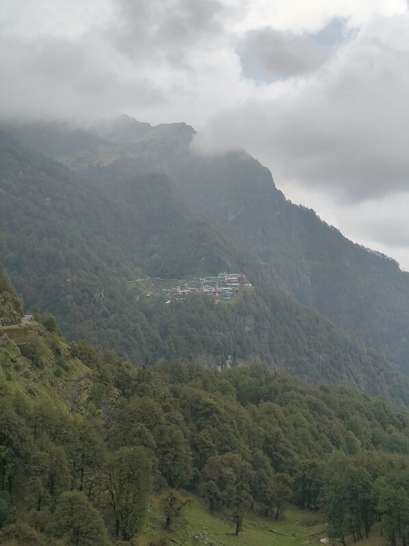 A mountainous landscape with a cluster of buildings on a hillside.