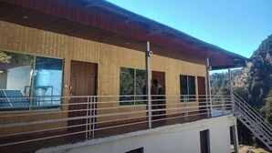 Un bâtiment moderne doté d’une façade en bois, de grandes fenêtres et d’un balcon agrémenté d’une balustrade.