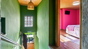 Une pièce avec un plafond en bois, une fenêtre, un lit et un téléviseur.