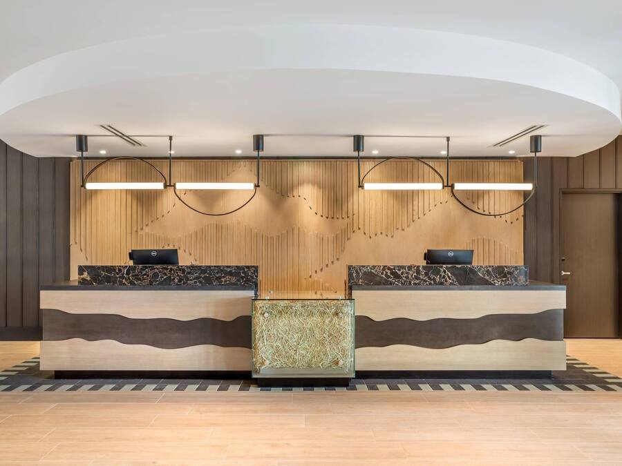 A reception desk with two counters, a modern light fixture, and a patterned floor.