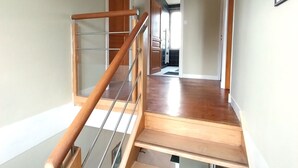 A staircase with wooden steps and metal railings leading to an upper floor.