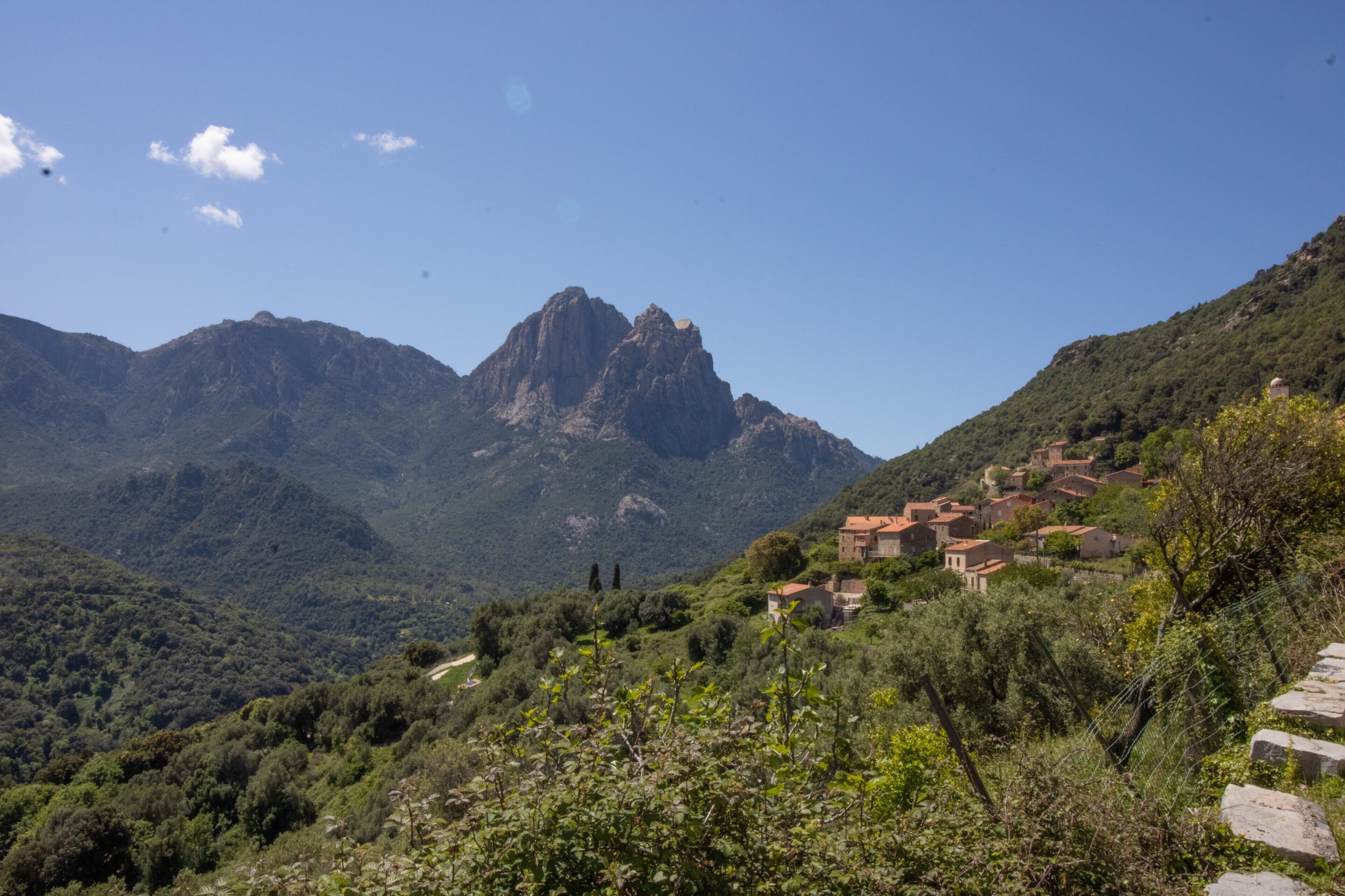 Un paisaje montañoso con un pueblo enclavado entre las colinas.