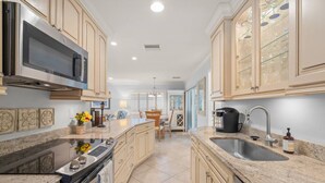 A kitchen with granite countertops, stainless steel appliances, and light-colored cabinetry.