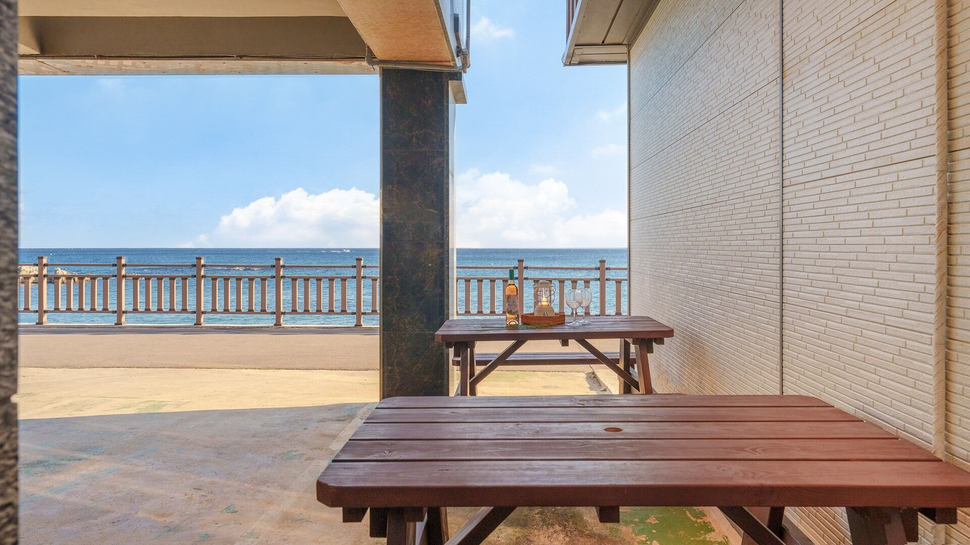 Un espacio de estar al aire libre cubierto con vista a la playa y el océano.