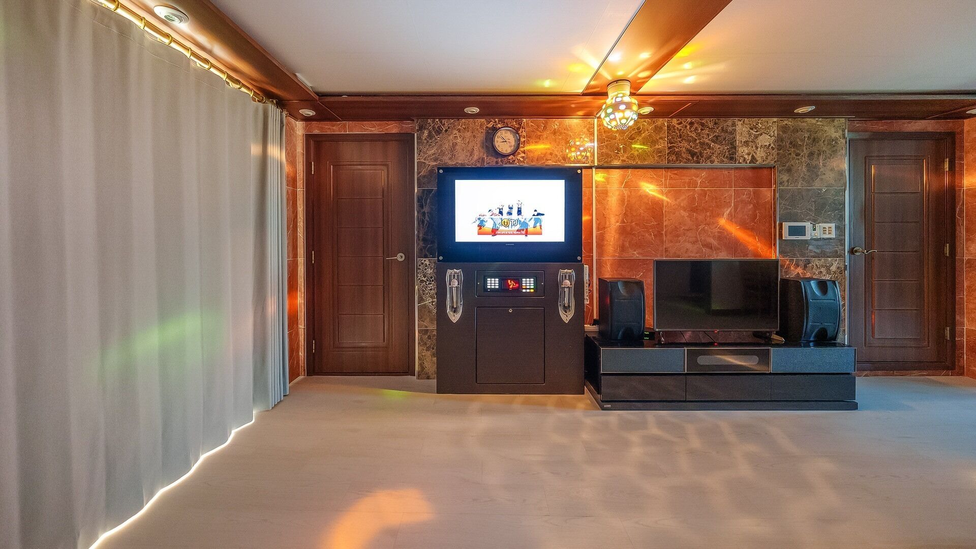 A hotel room with a television, a coffee machine, and a minibar.