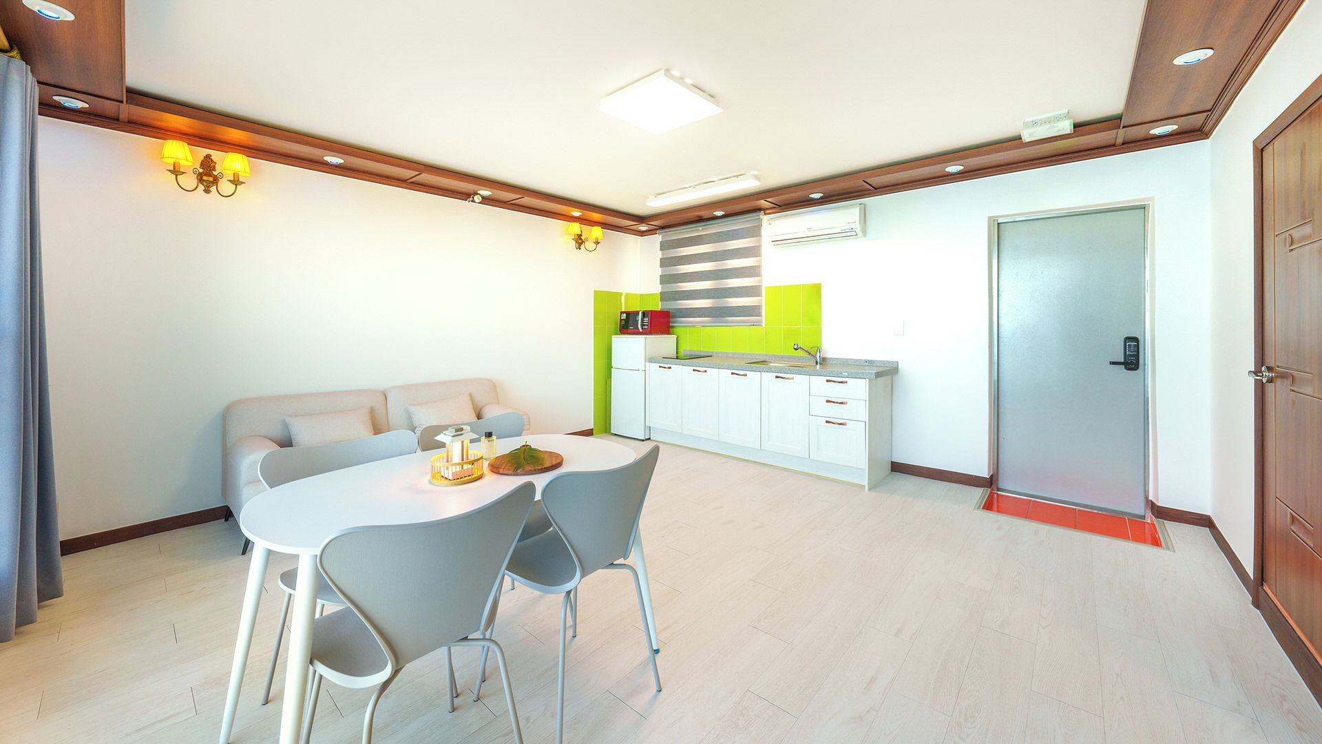 A modern kitchen with white cabinets, a grey countertop, and a red microwave.
