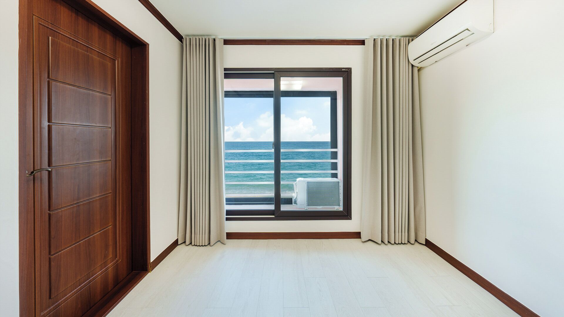Una habitación con un ventanal grande, una puerta corredera y un equipo de aire acondicionado.