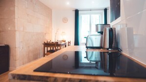 A modern kitchen with a built-in stove, a coffee maker, and a window with curtains. - Pop Art, Centre de Tours (Tours)