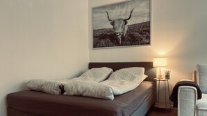 A bedroom with a bed, a nightstand, a lamp, and a framed picture on the wall. - Cozy Flats Silkeborg - S2 (Silkeborg)