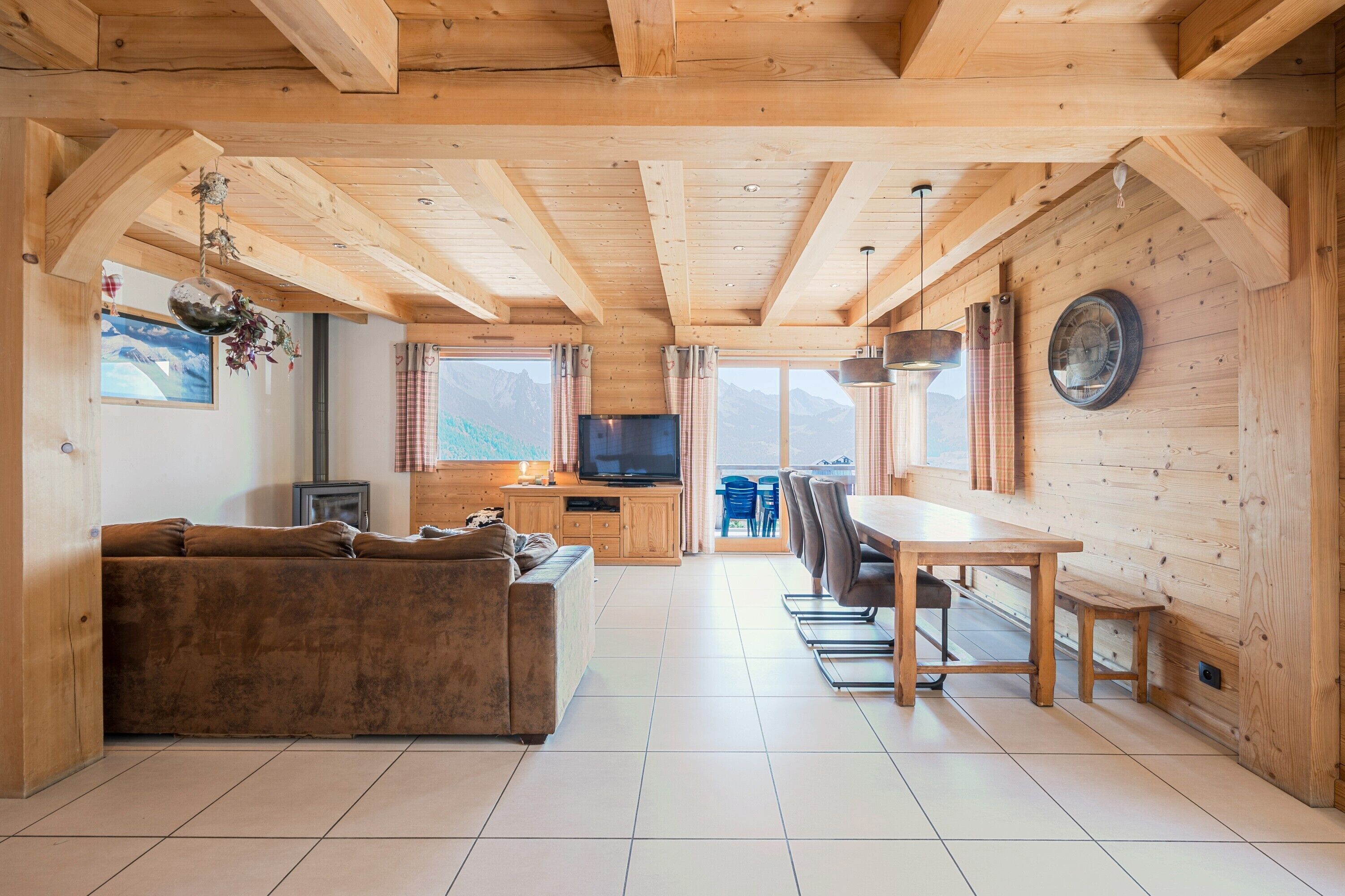Un interior de madera con un sofá, una mesa de comedor, sillas y un televisor.