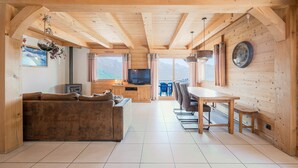 Arredamento in legno con divano, tavolo da pranzo, sedie e televisione.