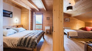 Una baita con due letti di legno, un tavolino e una finestra vista.