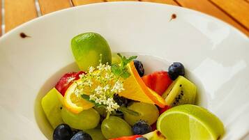 Eine Schale Obstsalat auf einem Holztisch, darunter eine rote Unterlage.