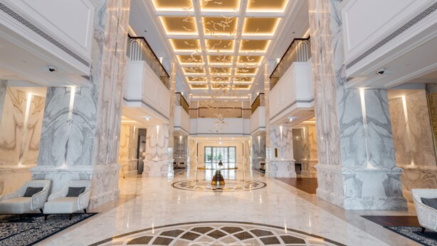 A spacious lobby with marble columns, a central fountain, and a high ceiling with recessed lighting. - Cheval Maison Expo City Dubai (Dubai)