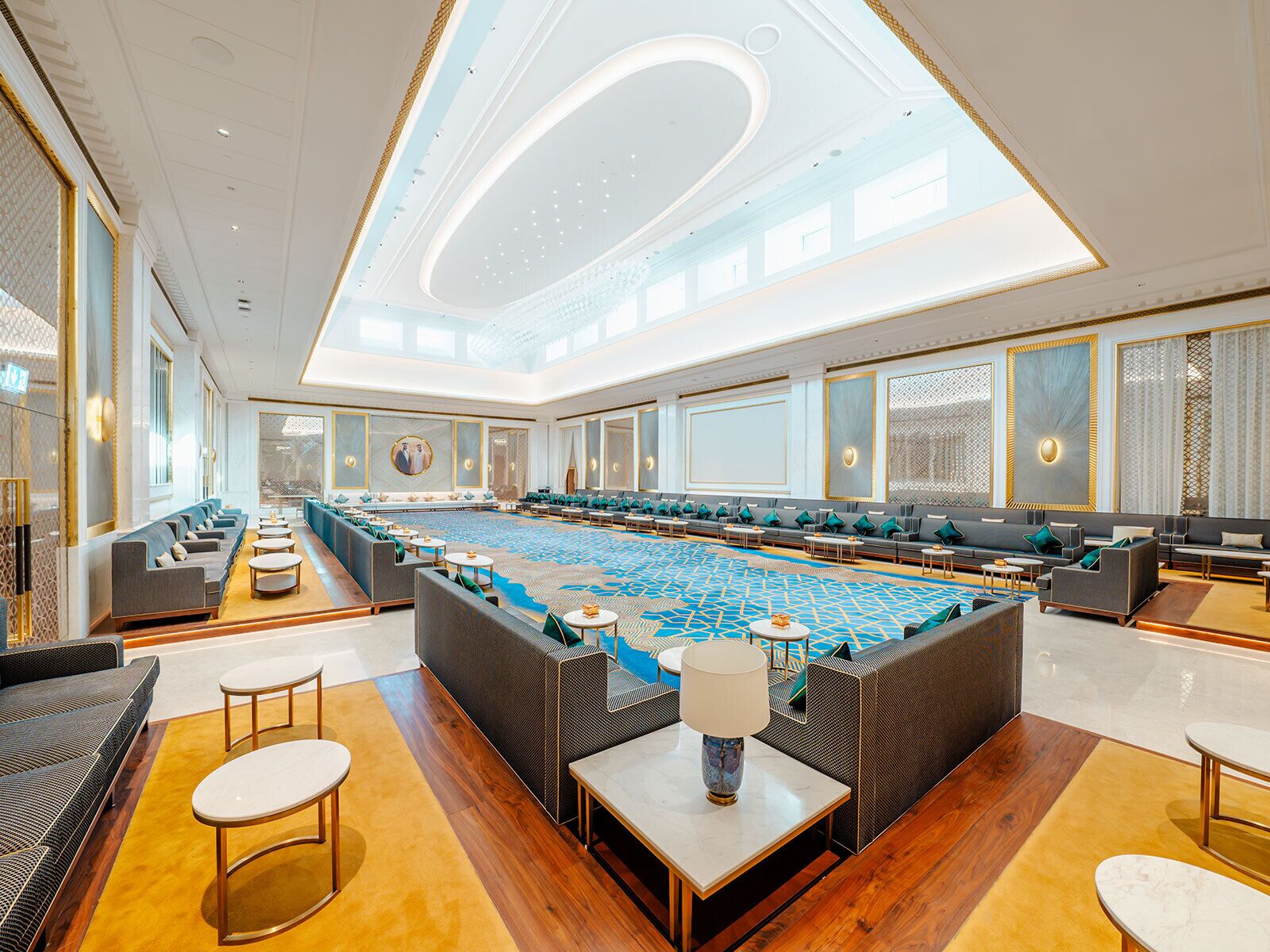 A spacious hotel lobby with a large seating area, a pool table, and a high ceiling with skylights.