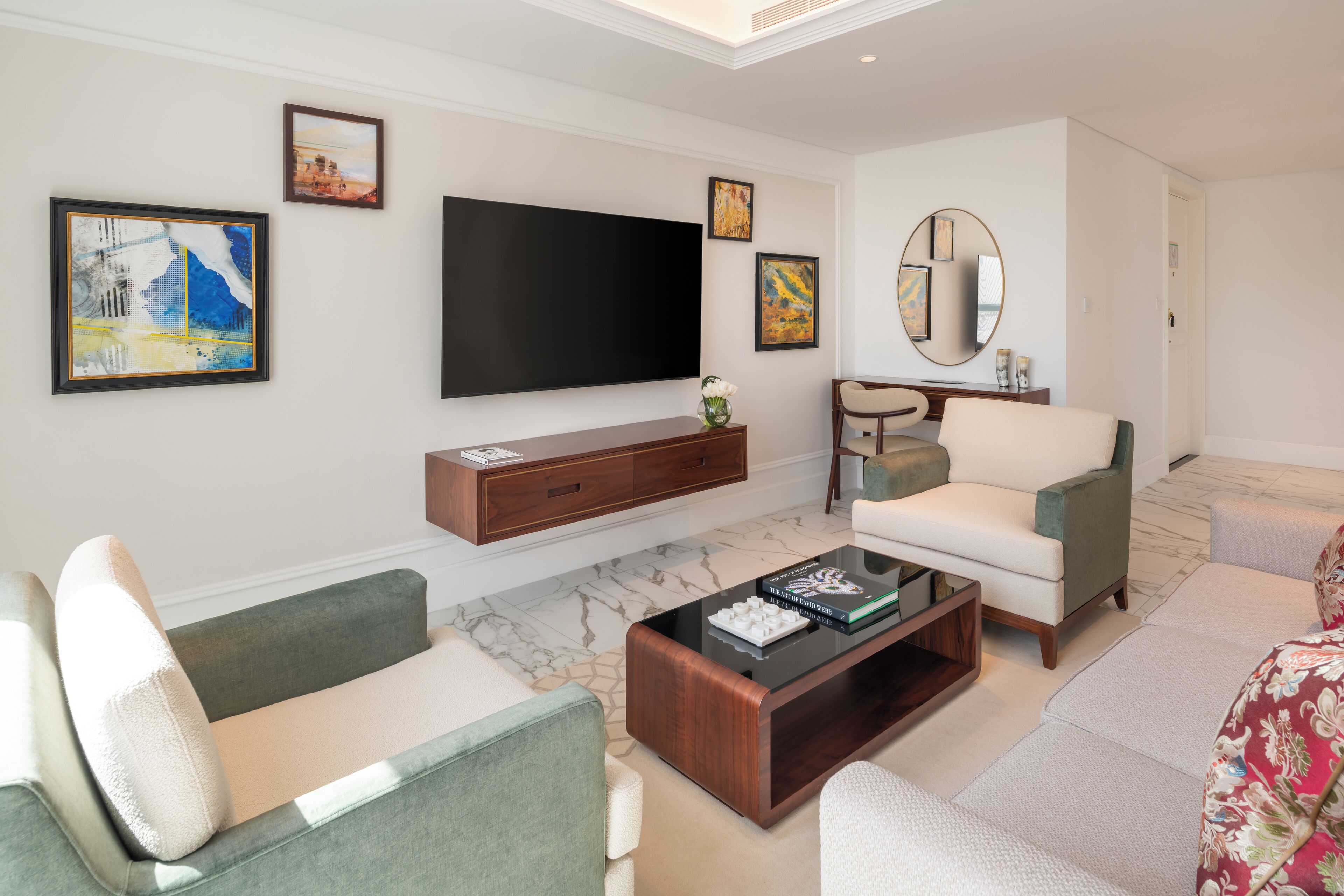 Una sala de estar moderna con un televisor de pantalla plana, una mesa de centro y dos sofás.