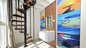 A modern interior with a spiral staircase, a white sink vanity, and a large scenic mural. - Pescadores B&B (Magong)