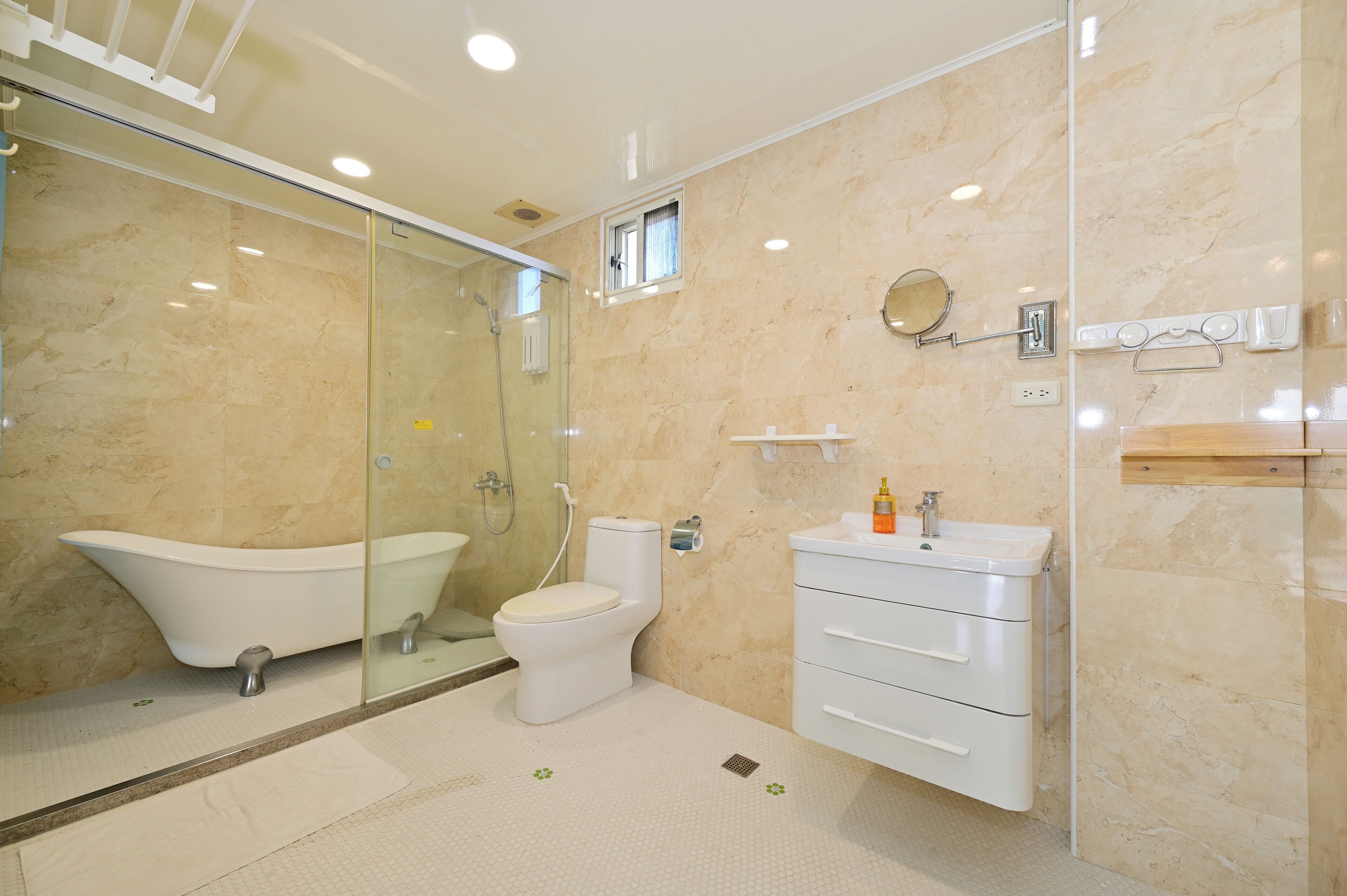 A modern bathroom with a freestanding bathtub, a toilet, a sink, and a glass-enclosed shower area.