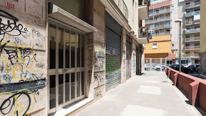 Un callejón estrecho con grafitis en las paredes y una puerta con persiana cerrada.