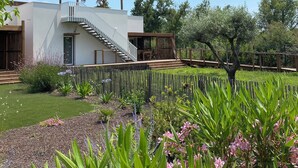A modern house with a staircase leading to a covered porch, surrounded by a garden with various plants and flowers. - Air-conditioned 3-bedroom villa with terrace, solarium and garden - V0767 (Vias)