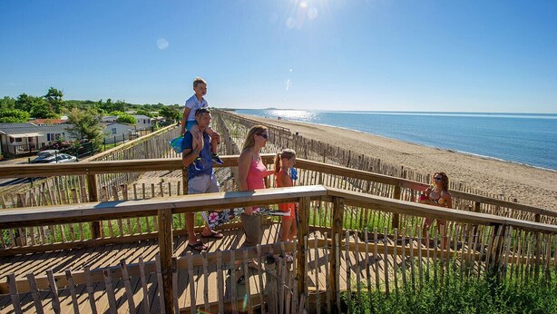 A wooden deck overlooking a beach with a clear sky and sun. - Air-conditioned 3-bedroom villa with terrace, solarium and garden - V0767 (Vias)