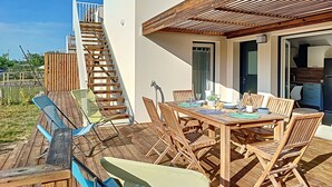 A wooden deck with a dining table and chairs, a staircase, and a view of the surrounding area. - Air-conditioned 3-bedroom villa with terrace, solarium and garden - V0767 (Vias)