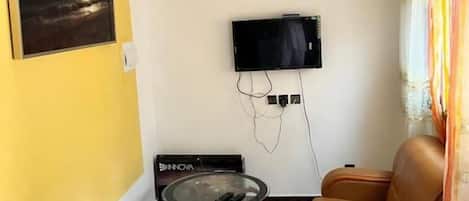 A living room with a TV, sofa, and a table.