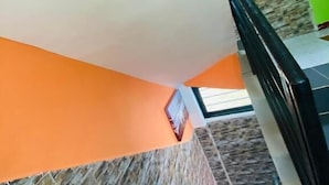 A staircase with a stone wall and orange walls. - Prestige Beach Residence (Kribi)