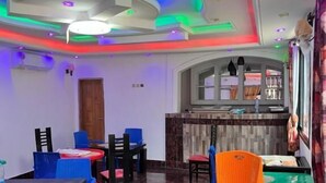 A restaurant interior with a modern ceiling design, marble flooring, and a variety of seating options including tables and chairs. - Prestige Beach Residence (Kribi)