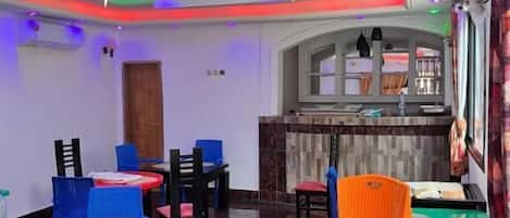 Interior de restaurante con un diseño moderno en el techo, suelo de mármol y diversas opciones de asientos, incluidas mesas y sillas.
