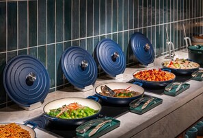 A buffet setup with various dishes and blue serving trays. - Manxin Hotel Wuhan Hankou Xinhua Road (Wuhan)