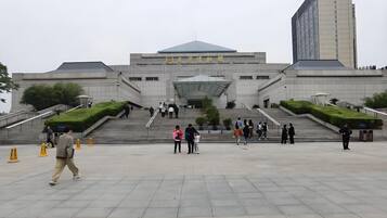 A large, modern building with a prominent entrance and wide steps leading up to it.