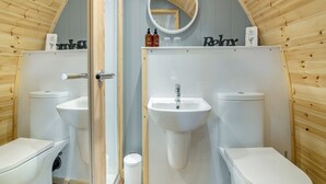 Een badkamer met twee wastafels, een toilet en een douche.