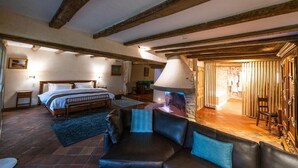 A bedroom with a bed, a sofa, a lamp, and a fireplace. - Auberge Saint Walfrid  (Sarreguemines)