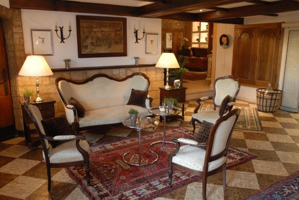 A traditional living room with a sofa, two armchairs, a coffee table, and a patterned rug.