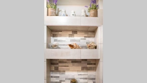Una cocina moderna con una encimera de dos niveles, baldosas decorativas y plantas en macetas.