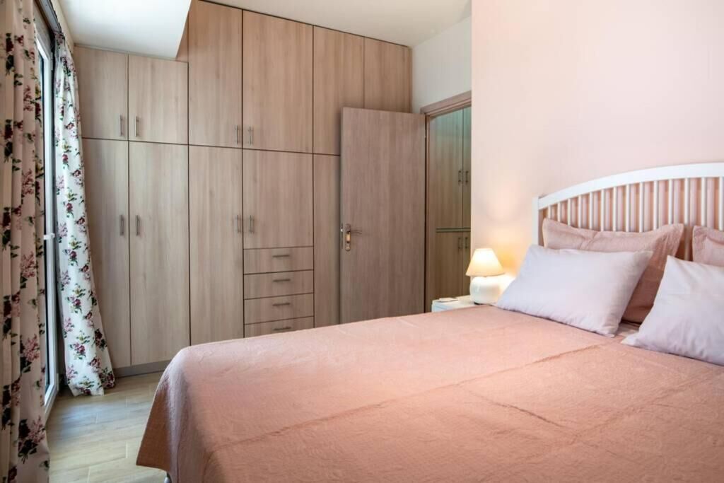 A bedroom with a bed, a nightstand, and a wardrobe.