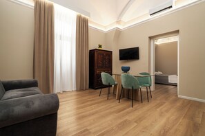 Suíte luxo, vista para a cidade | Área de estar | TV