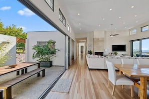 Ein modernes Interieur mit Essbereich, Wohnzimmer mit Sofagarnitur und Küchenzeile.