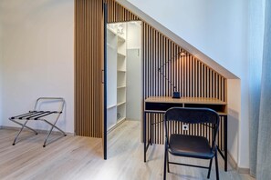 A compact room with a desk, chair, and a hanging clothes rack. - Vacation home Nordhorn - your cozy home in Koserow on the Baltic Sea (Ostseebad Kölpinsee)