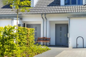 A building with a tiled roof, a bench, and a door. - Vacation home Nordhorn - your cozy home in Koserow on the Baltic Sea (Ostseebad Kölpinsee)