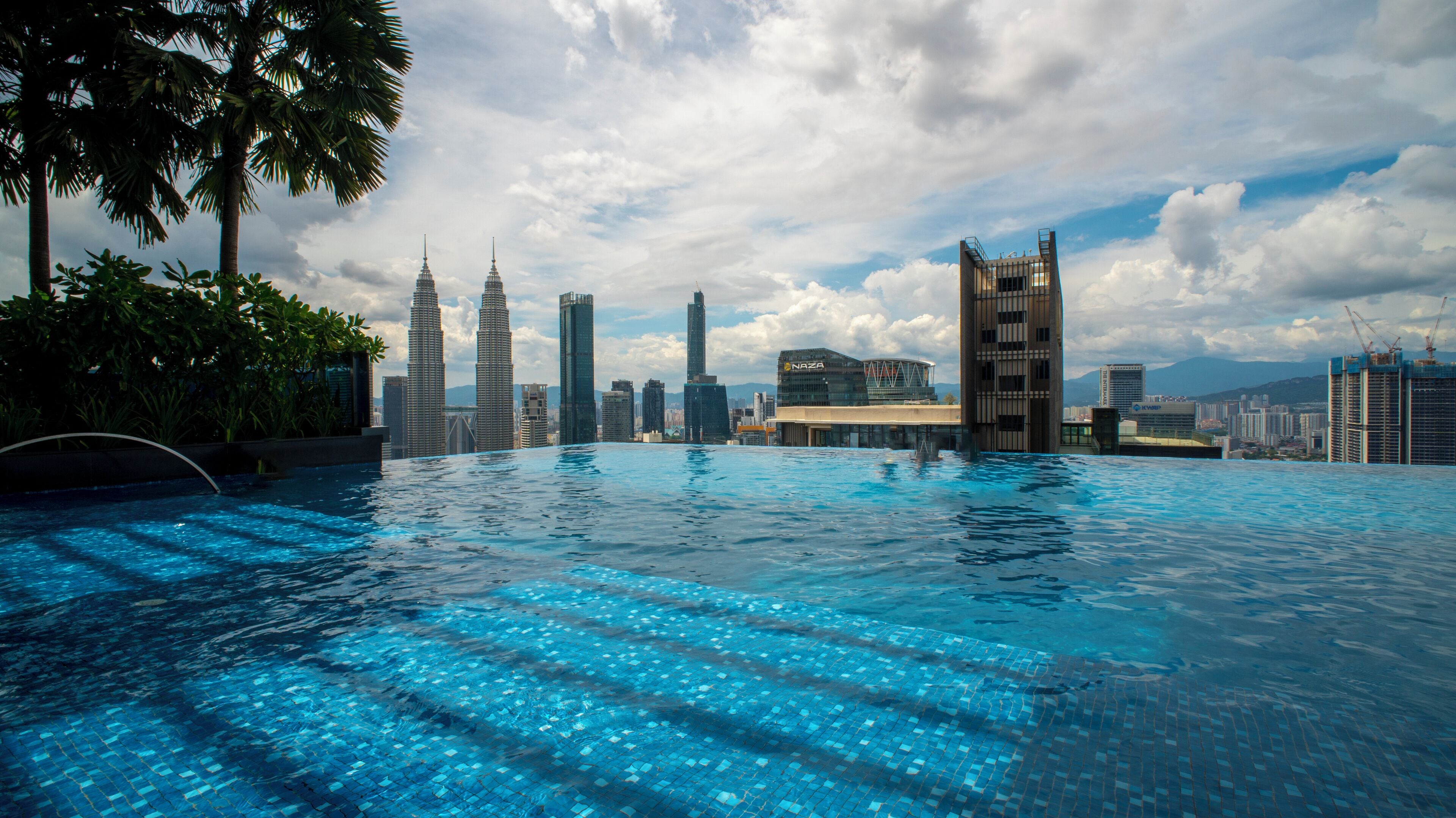 A swimming pool with a cityscape in the background.