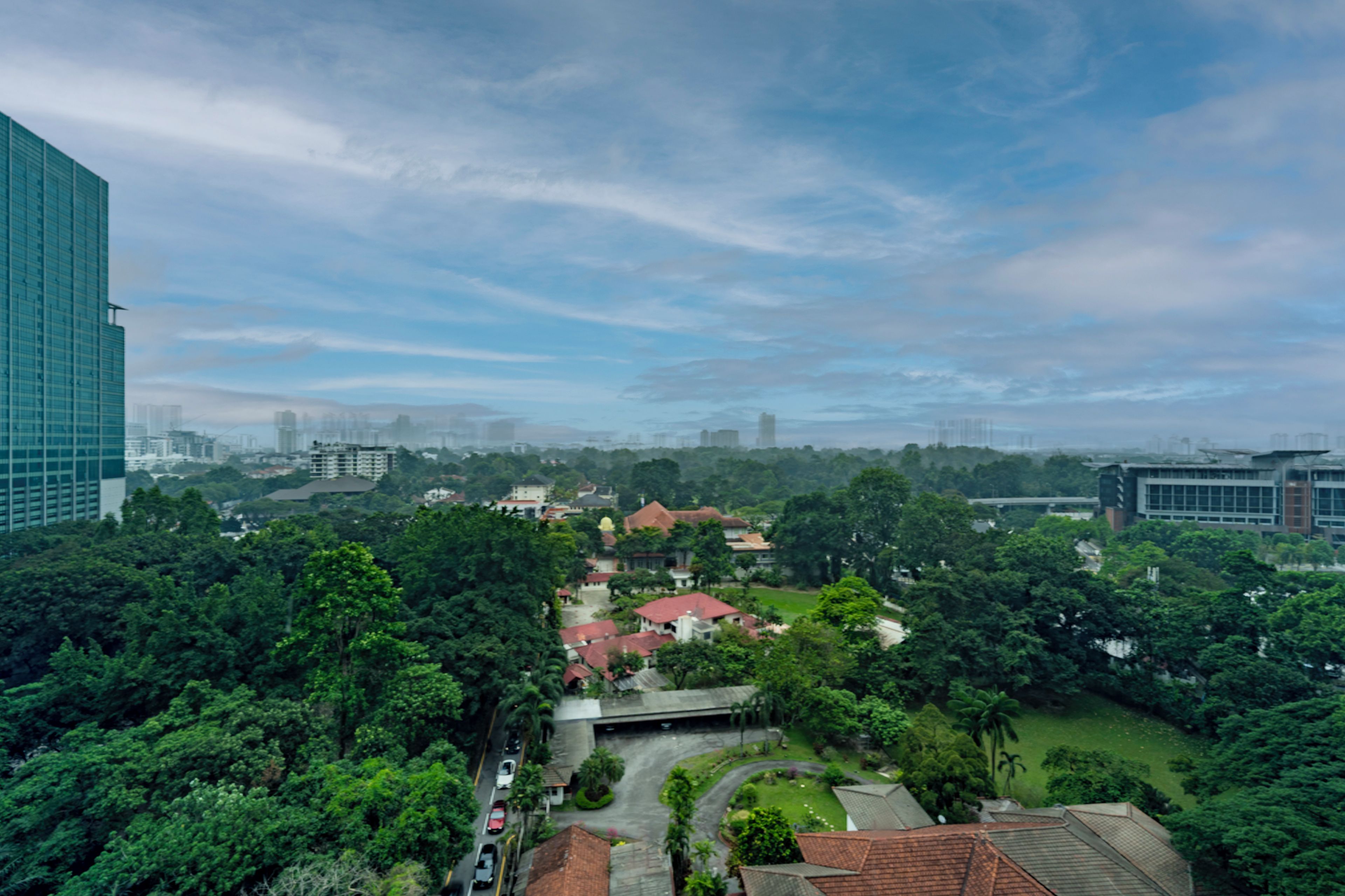 Un edificio de gran altura con vistas a una zona residencial con casas y vegetación.