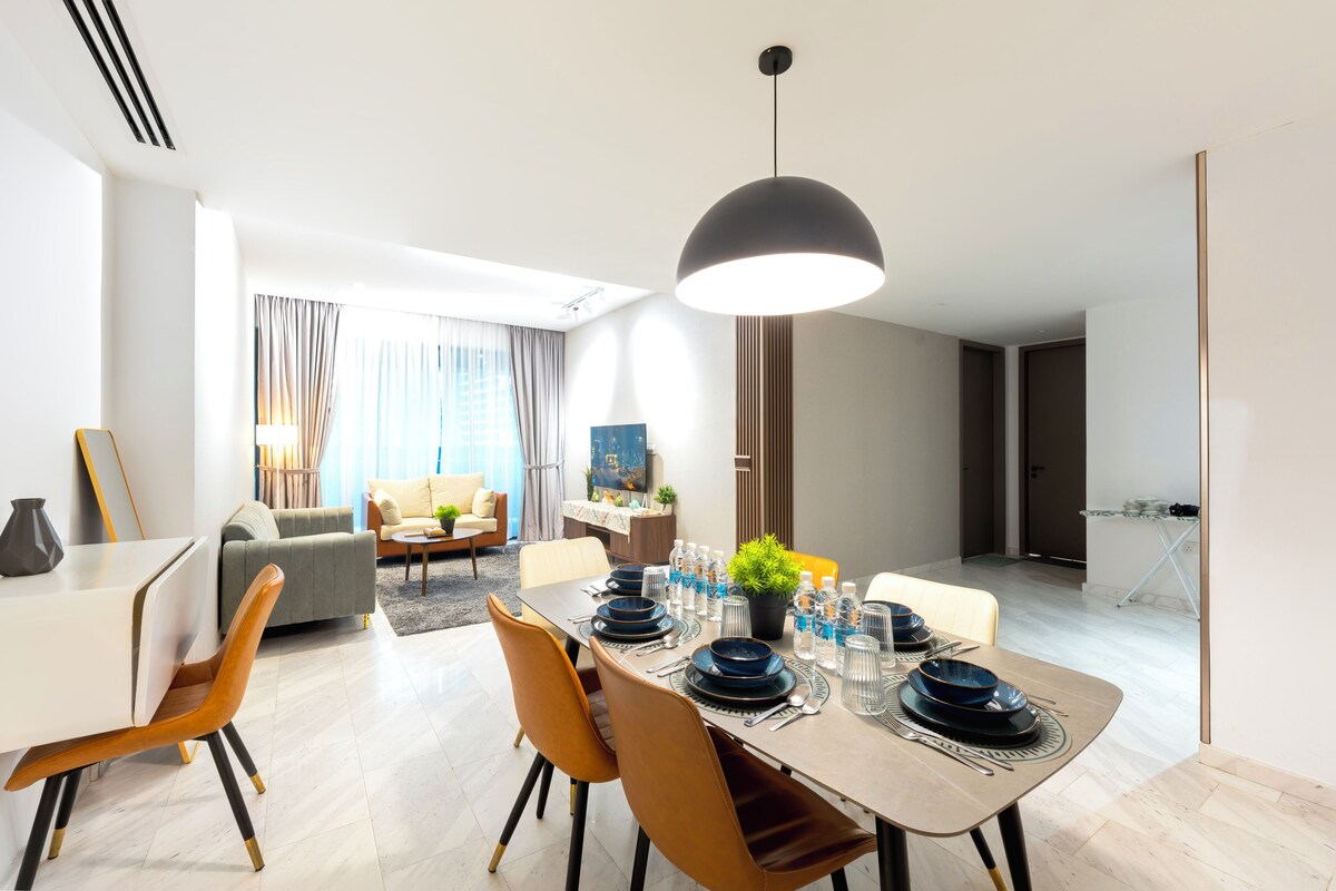 Un comedor moderno con una mesa grande dispuesta para cuatro personas, rodeado de asientos cómodos.