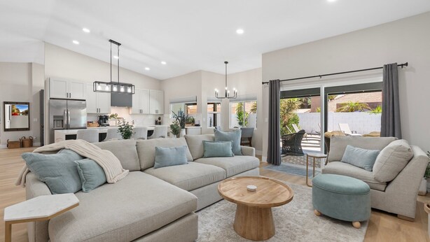 A modern living room with a sectional sofa, ottoman, and coffee table. - Private Pool, Hot Tub & Putting Green Home (Scottsdale)