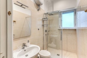 Ein modernes Badezimmer mit einer Duschkabine, einem Waschbecken und einer Toilette.