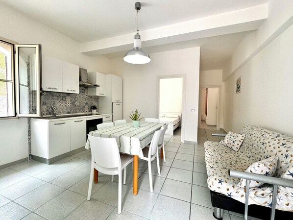 Un appartement moderne comprenant une cuisine, un coin repas et un salon.