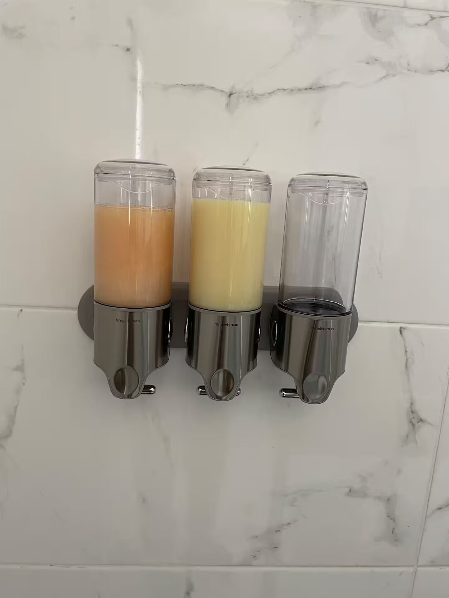 Three wall-mounted beverage dispensers with different colored liquids.