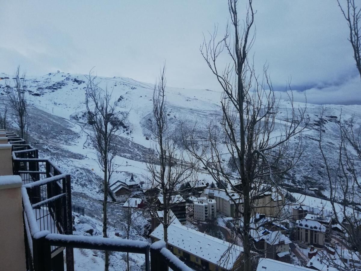 Un paysage montagneux enneigé, avec des bâtiments au premier plan.
